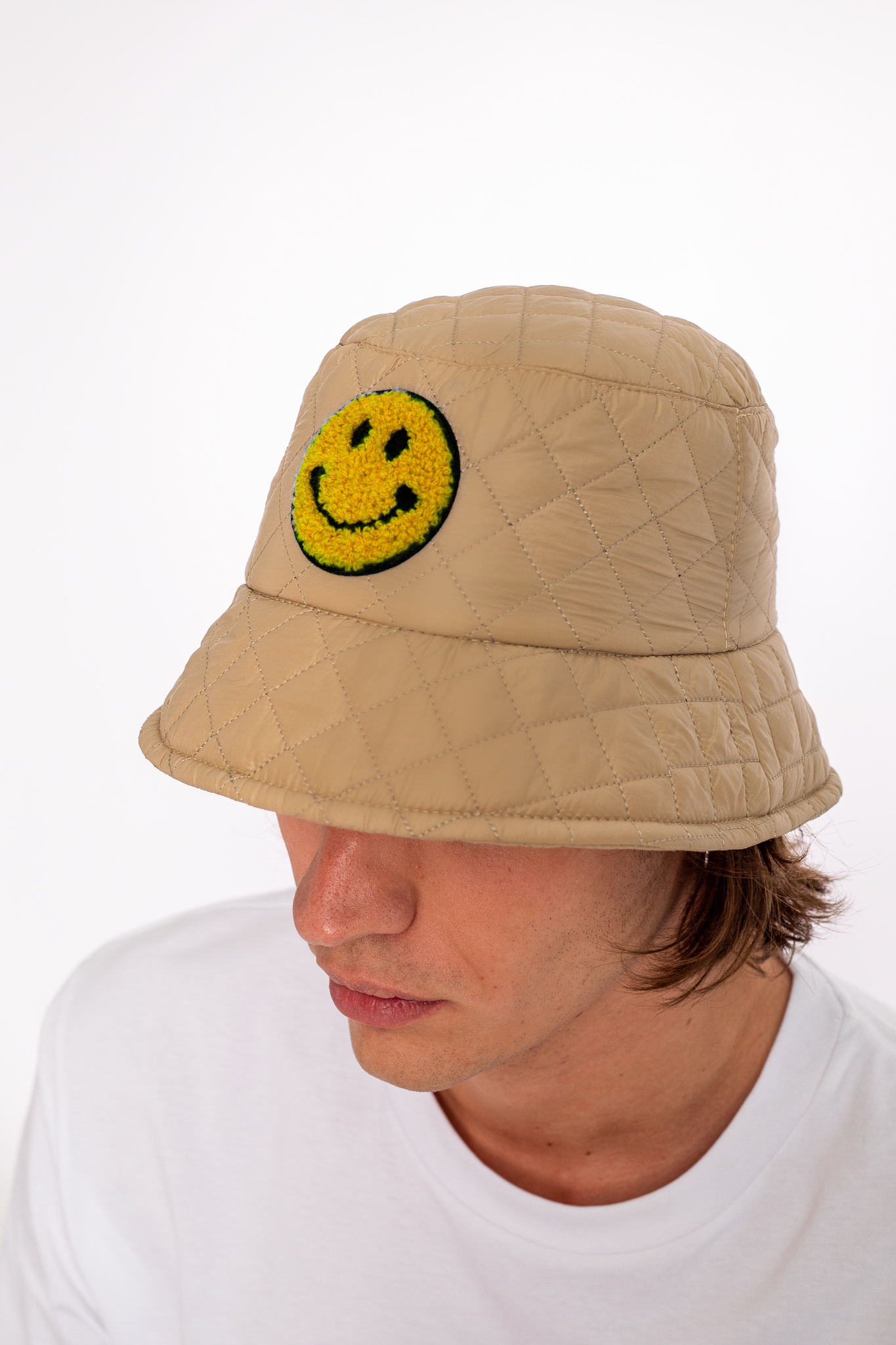 beige bucket hat with yellow smily face